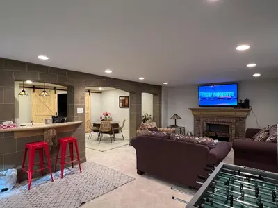 a living room with a couch and a bar with a tv at The McCleery Inn in Vancouver