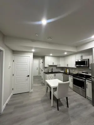 a kitchen with a white table and a white chair at Beautiful 2 bedroom 2 bath in NW Calgary in Calgary