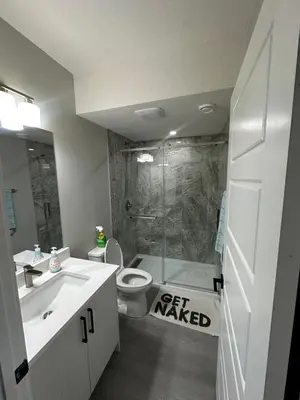 a bathroom with a toilet and a sink and a shower at Beautiful 2 bedroom 2 bath in NW Calgary in Calgary