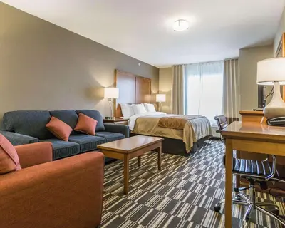 a hotel room with a bed and a couch at Comfort Inn & Suites Edmonton International Airport in Nisku