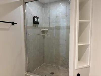 a shower with a glass door in a bathroom at Valley Home 2 Bed 1 Bath Walkout Basement Apartment, 1hr to Banff, 40 Mins Canmore, 5 mins to WinSport & Olympic park in Calgary