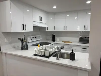 a kitchen with white cabinets and a sink at Valley Home 2 Bed 1 Bath Walkout Basement Apartment, 1hr to Banff, 40 Mins Canmore, 5 mins to WinSport & Olympic park in Calgary