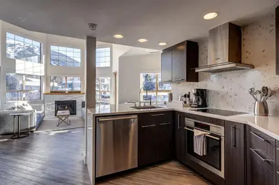 a kitchen with stainless steel appliances and a living room at Tyndall Stone 317 by Outpost Whistler in Whistler