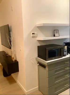 a living room with a tv and a microwave at City Center Olive Grove in Kamloops