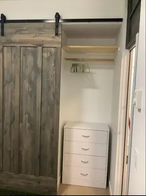 a closet with a wooden cabinet and a white dresser at City Center Olive Grove in Kamloops
