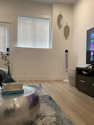 a living room with a table and a tv at Sapphire Lux Queen Suite in Kamloops