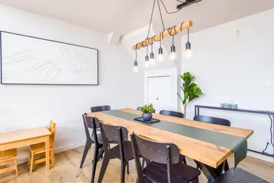 a dining room with a wooden table and chairs at Wintergreen Retreat w/Hot Tub by Village in Kelowna