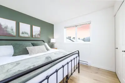 a bedroom with a large bed and a window at Wintergreen Retreat w/Hot Tub by Village in Kelowna