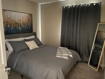 a bedroom with a bed and a mirror in it at Mahogany's Comfy Haven in Calgary