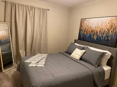 a bedroom with a bed with a painting on the wall at Mahogany's Comfy Haven in Calgary