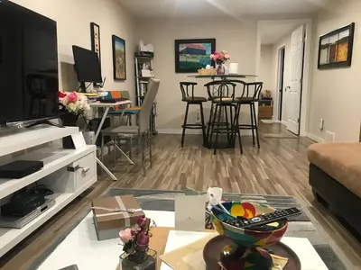 a living room with a couch and a table with chairs at Dolly's Deluxe Suite in Fort Saskatchewan