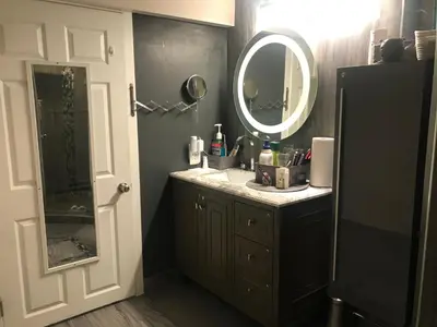 a bathroom with a sink and a mirror at Dolly's Deluxe Suite in Fort Saskatchewan
