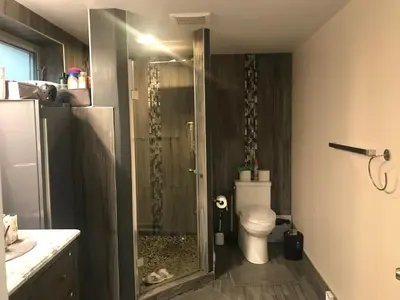 a bathroom with a shower and a toilet in it at Dolly's Deluxe Suite in Fort Saskatchewan