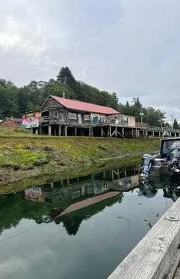 a boat parked in front of a building next to a body of water at Sweet Home Alert Bay in Alert Bay