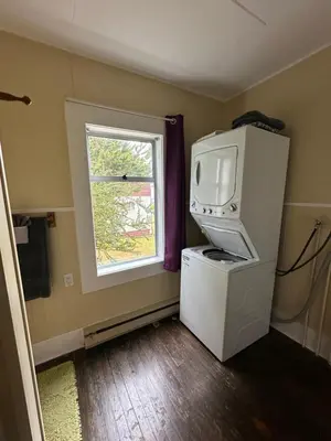 a small room with a refrigerator and a window at Sweet Home Alert Bay in Alert Bay