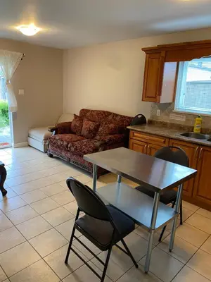 a living room with a table and a couch at Large suite with separate access in Richmond
