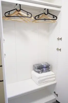 a closet with white walls and a shelf with towels at Center of the City in Vancouver