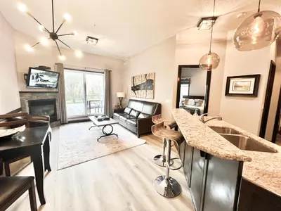 a kitchen and living room with a counter top at Cozy Canmore resort with mt view hot tub and pool in Canmore