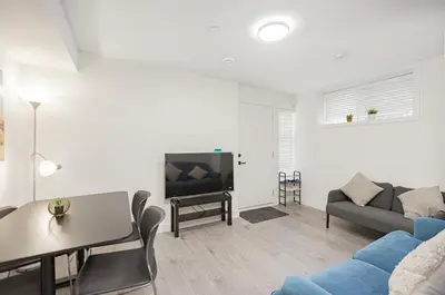 a living room with a couch and a table and a tv at Dumfries Guest Room in Vancouver in Vancouver