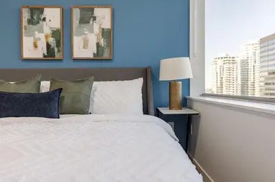 a bedroom with a white bed and a blue wall at DT Edmonton King Suite with Parking & 100 Walk Score in Edmonton