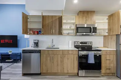 a kitchen with wooden cabinets and a stove and microwave at DT Edmonton King Suite with Parking & 100 Walk Score in Edmonton
