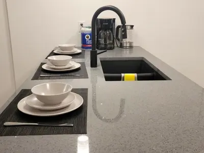 a kitchen counter with a sink and two cups and saucers at Lovely Modern 2 Bedroom Basement Suite in Edmonton
