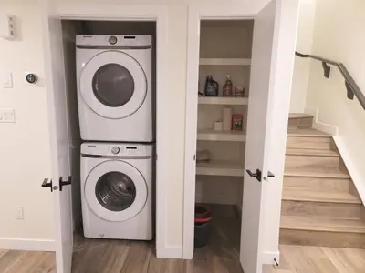 a laundry room with a washer and dryer at Lovely Modern 2 Bedroom Basement Suite in Edmonton