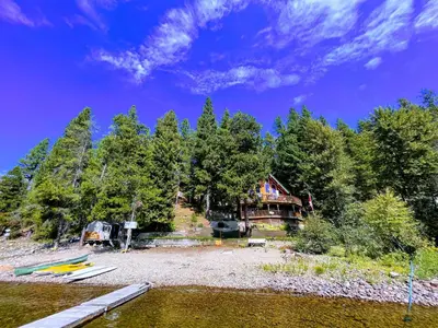 a house on the shore of a body of water at Beachfront Lake House Moyie BC in Moyie