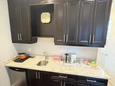 a kitchen with black cabinets and a sink at Kane Jolly Lodge in Richmond
