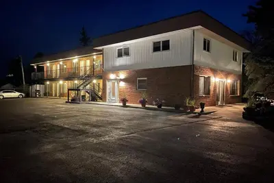 a house with lights on the side of it at night at Rest Easy Motel in Three Hills