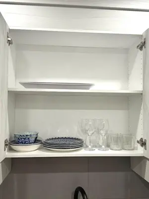 a white cabinet with plates and glasses on it at Luxe Stay with a Designer Touch in Calgary