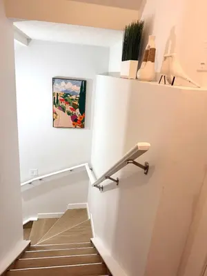 a staircase in a house with a painting on the wall at Luxe Stay with a Designer Touch in Calgary