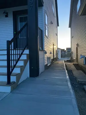 an empty sidewalk in front of a house with stairs at Luxe Stay with a Designer Touch in Calgary