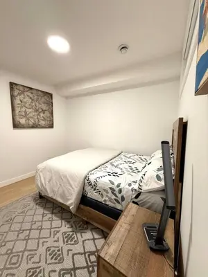 a bedroom with a bed and a desk with a computer at Luxe Stay with a Designer Touch in Calgary