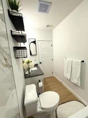 a bathroom with a toilet and a sink at Luxe Stay with a Designer Touch in Calgary