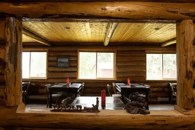 a room with tables and chairs in a log cabin at Tatogga Lake Resort in Iskut