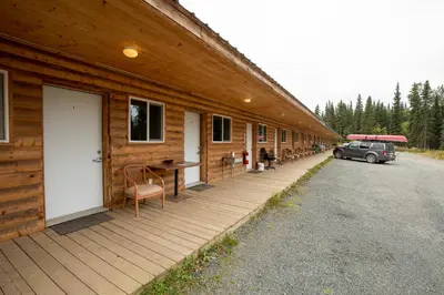 a wooden building with a car parked outside of it at Tatogga Lake Resort in Iskut