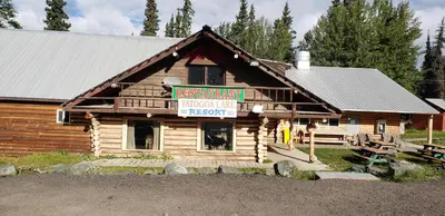 a log cabin with a sign for a restaurant at Tatogga Lake Resort in Iskut