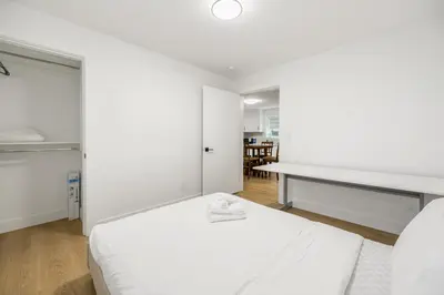 a white bedroom with a bed and a desk at A cozy and stylish 2-bedroom retreat in Surrey