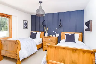 two beds in a bedroom with blue walls at Perfection South 1 in Big White