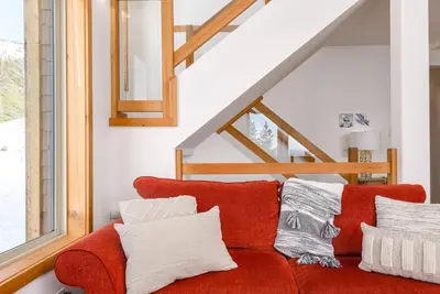 a red couch with white pillows in a living room at Perfection South 1 in Big White