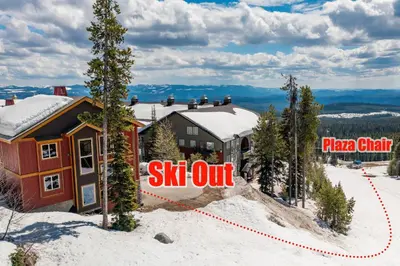 a house in the snow with a sign that reads ski out at Perfection South 1 in Big White