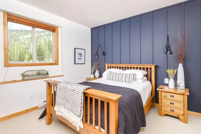 a bedroom with a bed and a blue wall at Perfection South 1 in Big White