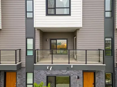 an apartment building with a balcony on the side at 3 Bedroom Luxurious Seton Town Home with Central AC and Lake View in Calgary