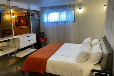 a bedroom with a bed and a dresser and a mirror at Main Street Suites Nanton in Nanton