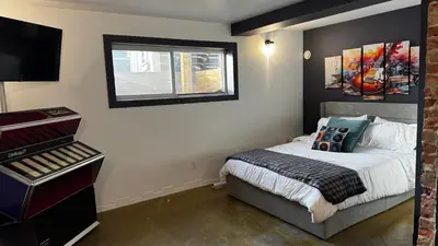 a small bedroom with a bed and a window at Main Street Suites Nanton in Nanton