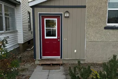 a red door on the side of a house at Main Street Suites Nanton in Nanton