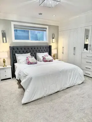 a bedroom with a large white bed and a window at Luxury Chestermere Retreat in Calgary