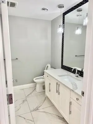 a white bathroom with a sink and a mirror at Luxury Chestermere Retreat in Calgary