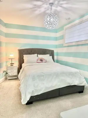 a bedroom with a large bed with striped walls at Luxury Chestermere Retreat in Calgary